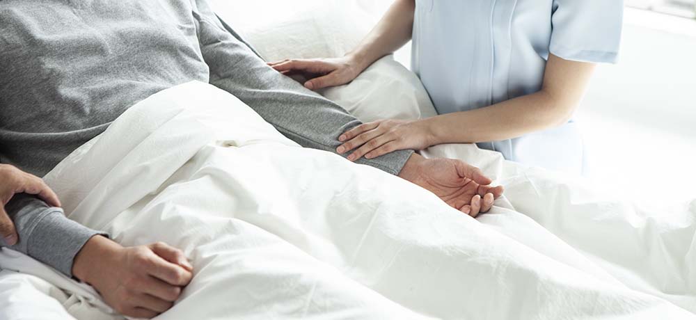 病院のベッドに横たわる患者の写真