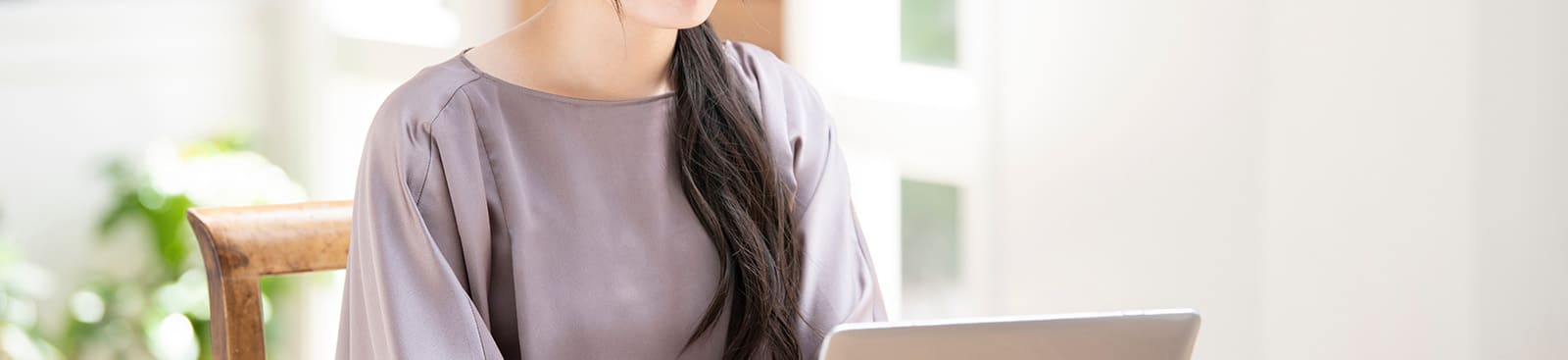 ノートパソコンを開いて調べものをしている女性