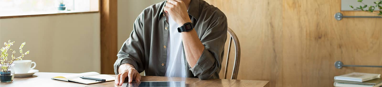 タブレットを見ながら悩む男性の写真